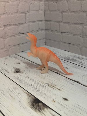 Игрушечный динозавр светящийся в темноте